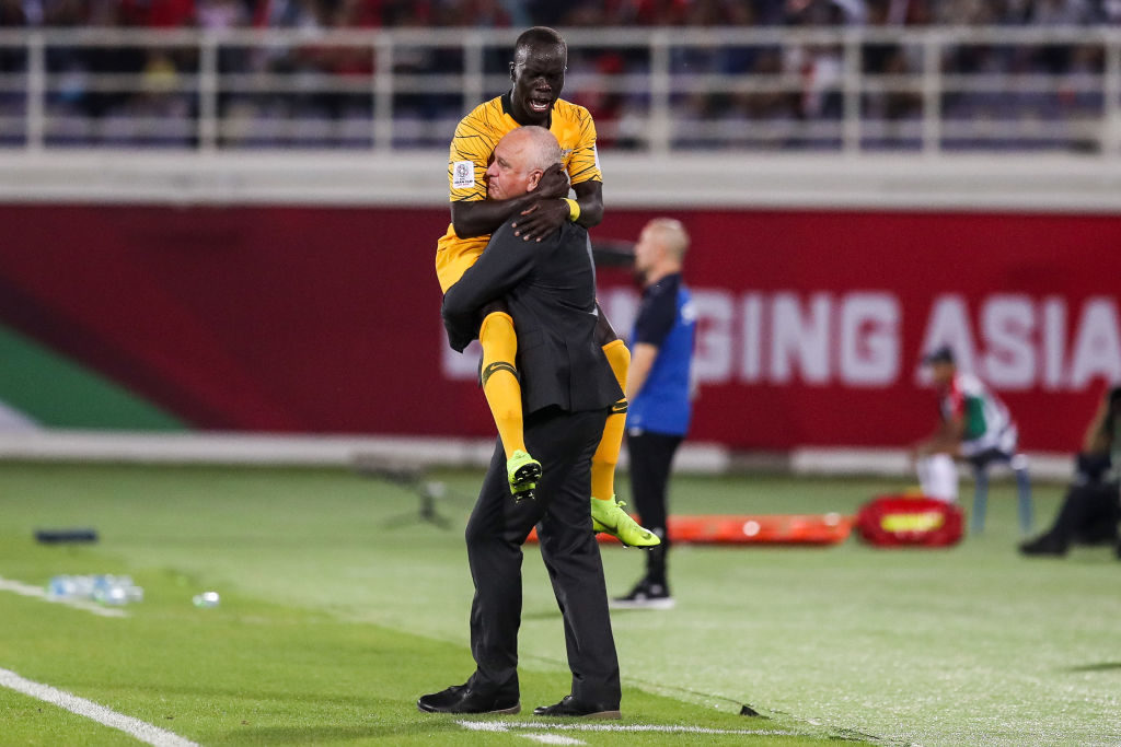 AL AIN, UNITED ARAB EMIRATES - JANUARY 15: #21 Awer Mabil of Australia celebrates his scoring with Graham Arnold coach of Australia during the AFC Asian Cup Group B match between Australia and Syria at Khalifa Bin Zayed Stadium on January 15, 2019 in Al Ain, United Arab Emirates.