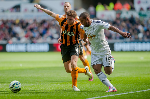 SWANSEA, WALES - APRIL 04: ( L-R )  Alex Bruce of Hull City  and Wayne Routledge of Swansea City  in action during the Premier League match between...