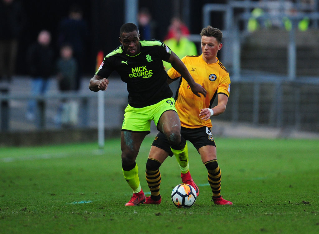 NEWPORT, WALES - DECEMBER 03: Cambridge United's Uche Ikpeazu under pressure from Newport County's Ben White during the Sky Bet League Two match between Newport County and Cambridge United at Rodney Parade on December 3, 2017 in Newport, Wales.