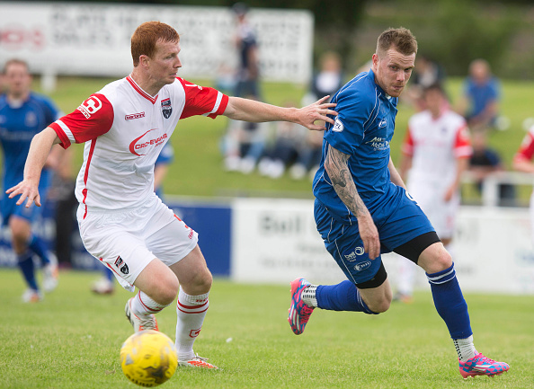 ELGIN, SCOTLAND - JULY 11: Scott Boyd of Ross County (left) gets beaten by Craig Gunn of Elgin at the Pre Season Friendly between Elgin and Ross County at Borough Briggs on July 11th, 2015 in Elgin, Scotland.