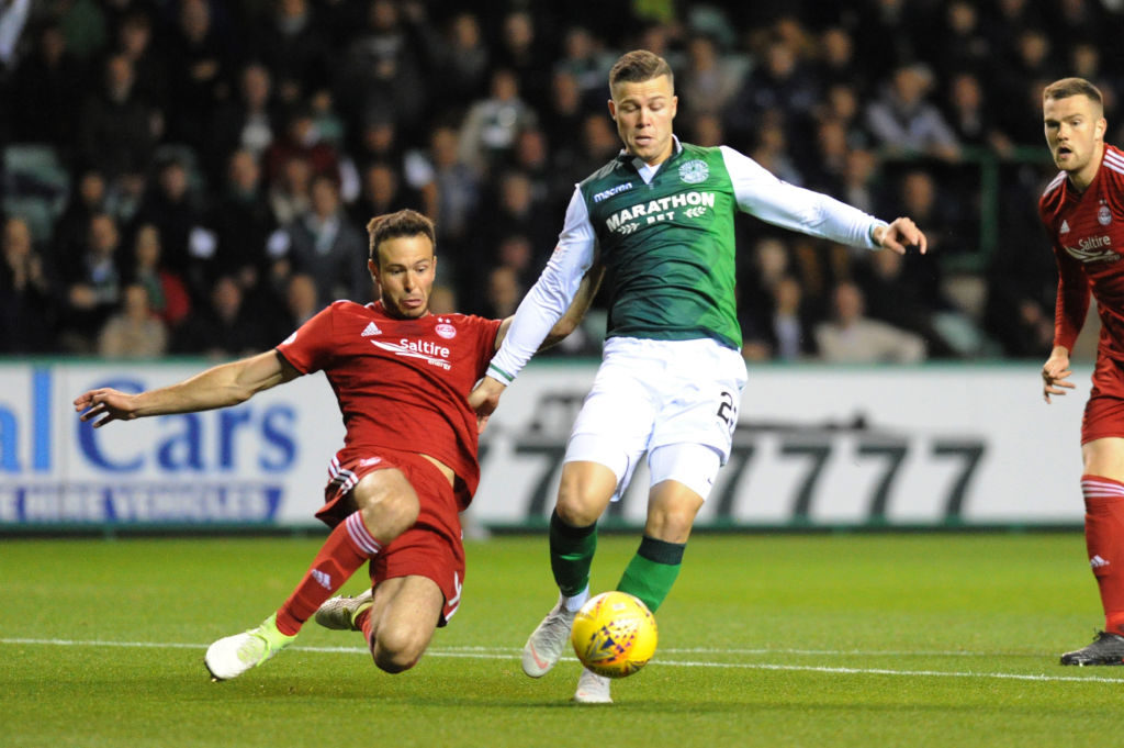 EDINBURGH, SCOTLAND - SEPTEMBER 25: Andrew Considine (L) of Aberdeen FC attempts to slide in on Florian Kamberi (R) of Hibernian FC during the Scottish League Cup match between Hibernian and Aberdeen at Easter Road on September 25, 2018 in Edinburgh, United Kingdom.