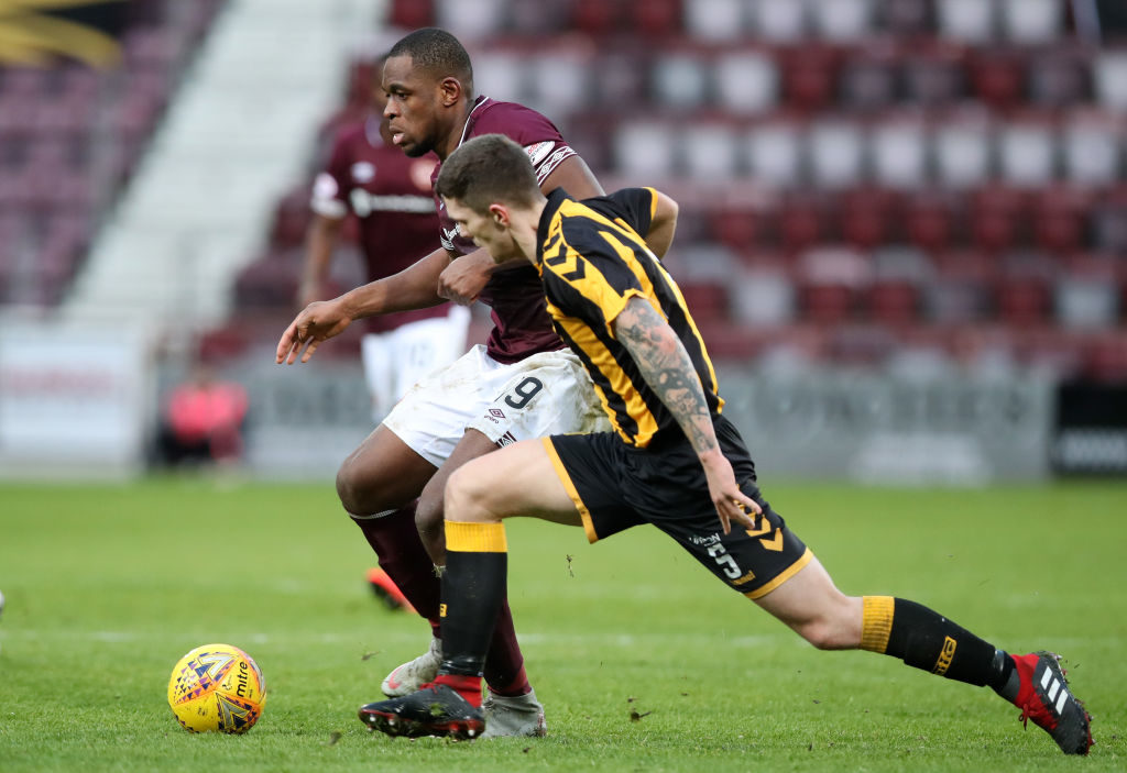 EDINBURGH, SCOTLAND - FEBRUARY 10: Uche Ikpeazu of Hearts battles for possession with Craig McCracken of Auchinleck Talbot during the Scottish Cup 5th Round match between Heart of Midlothian and Auchinleck Talbot at Tynecastle Stadium on February 10, 2019 in Edinburgh, Scotland.