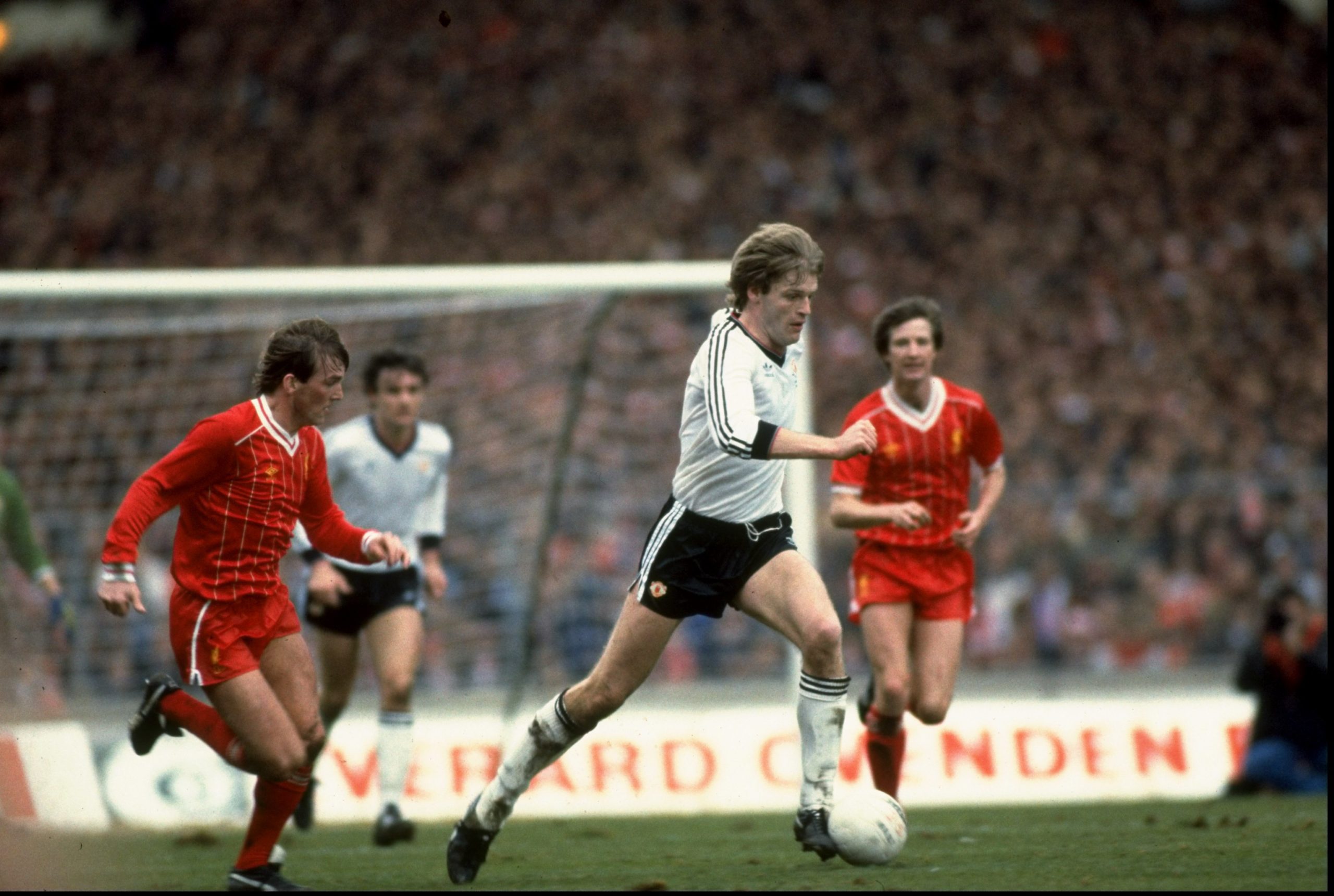 1983:  Gordon McQueen of Manchester United is chased by Kenny Dalglish of Liverpool during the Milk Cup Final match played at Wembley Stadium in Lo...